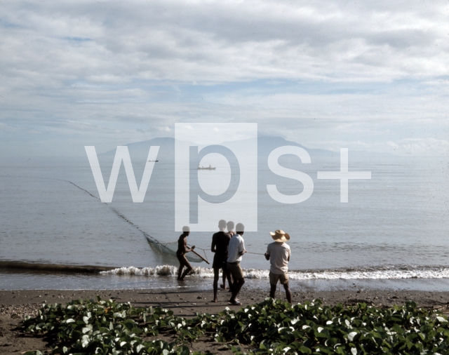 ｜ディリ海岸で網を引く漁師とアタウロ島
