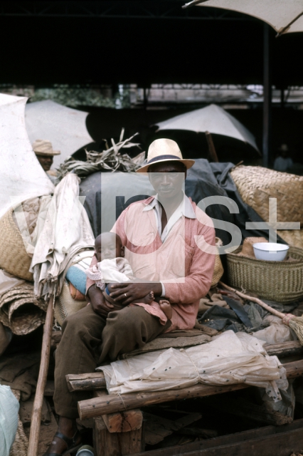 ｜イソトリ市場で幼児を抱くメリナ族の男性